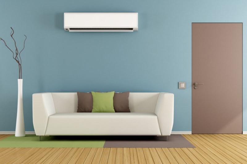 Why Ductless Is the Way to Go. Contemporary living room with white sofa, air conditioner and closed door - 3D Rendering.